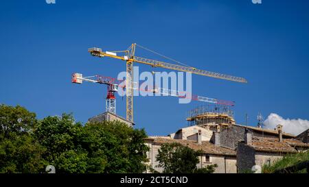 Two big cranes stand over a small Italian village.They are  for reconstructing the village after the earthquake of L'Aquila  in 2009 Stock Photo