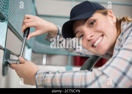 happy woman installing blinds with screwdriver Stock Photo