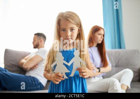 little daughter girl doesn't want parents to be divorced, sad girl listen to quarrels of parents, want happy family Stock Photo