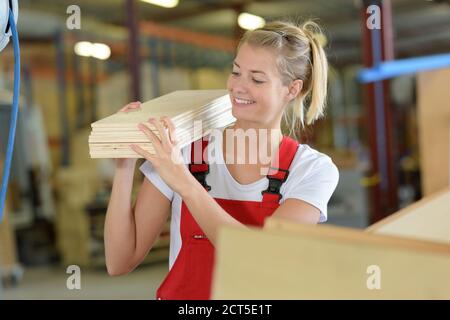 builder and female apprentice carrying wood on site Stock Photo