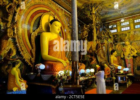 Sri Lanka Colombo - Old Buddhist temple Gangaramaya Prayer in front of Buddha statues Stock Photo