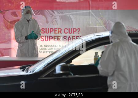 Munich, Germany. 21st Sep, 2020. Topic picture Corona PCR test for fans of FC Bayern Munich who are going to the Supercup Final after Budapest/Hungary, a Corona risk area. Corona hotspot. Medical staff wears a protective suit and face shield, full face mask, face mask, mask and takes a swab from people who pull up the car in a drive through test station, 21.09.2020 | usage worldwide Credit: dpa/Alamy Live News Stock Photo