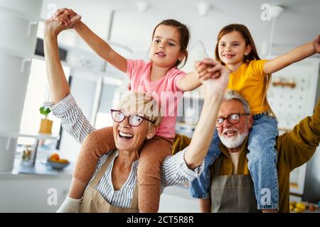 Grandchildren having fun, playing with grandparents at home Stock Photo