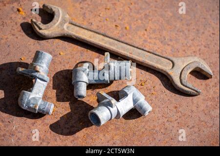 Old wrench and metal parts on a rusty sheet of metal, close-up, selective focus Stock Photo
