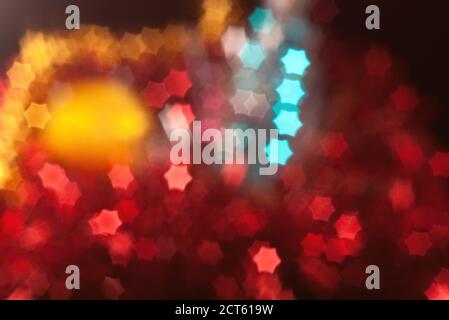 Out of focus and blurred red Christmas tinsel with star shape lights Stock Photo