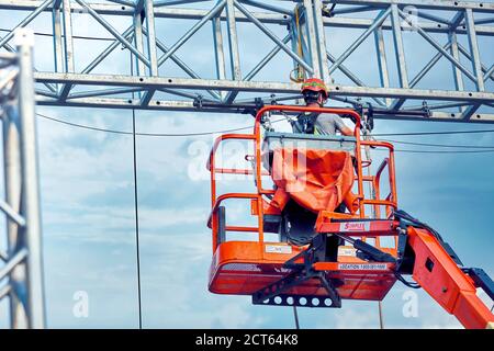 Montreal, Canada - June, 2018: Municipal worker with helmet and safety protective equipment in lift bucket in Montreal, Quebec, Canada. Stock Photo