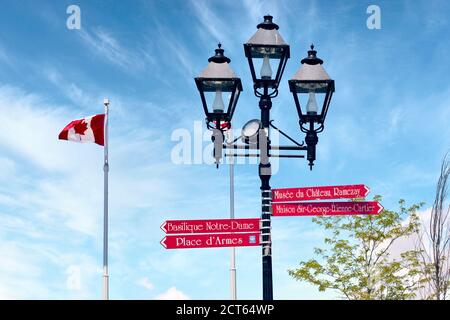 Montreal, Canada - June, 2018: Red arrow street signs mounted on a lamp post with canadian flag in Montreal, Quebec, Canada. Stock Photo