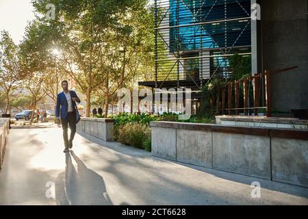 Stylish young businessman walking to work in the city Stock Photo