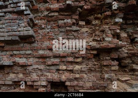 the background is an old dilapidated wall made of vintage three-dimensional weathered bricks. Stock Photo