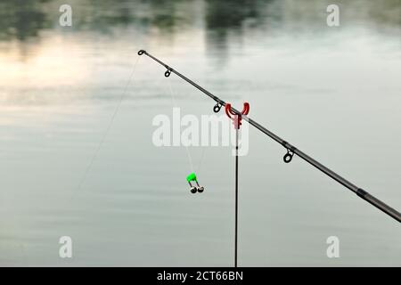 Fishing rod bell on fishing line, lake at sunset background Stock Photo -  Alamy