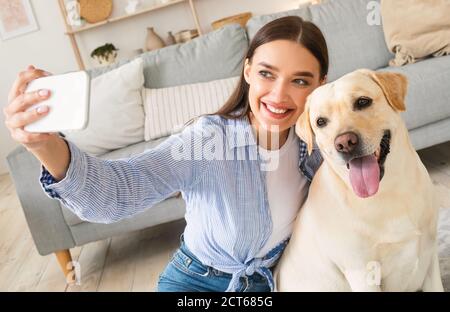 Young woman with her dog taking selfportrait Stock Photo