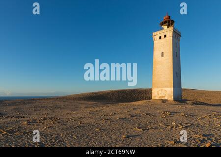 The defunct lighthouse at Rubjerg Knude, Denmark, in golden evening sunlight Stock Photo