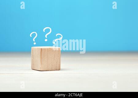 Wooden block with question marks at the top. Uncertainty, confusion, surprise or faq concept. Stock Photo