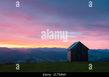Rural Romanian landscape at sunrise in the Bukovina Region (Bucovina), Paltinu, Romania, background with copy space Stock Photo
