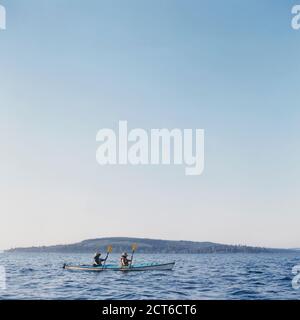 Middle aged man and woman sea kayaking on calm water Stock Photo