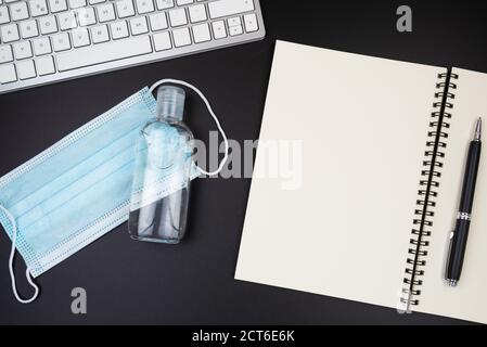 above view of disposable face mask and hand sanitizer on office desk Stock Photo