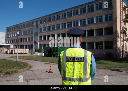 Oranienburg, Germany. 21st Sep, 2020. A police officer stands in front of the former police station in Oranienburg (Brandenburg). The dilapidated and old building is to be demolished to make room for the planned dormitory of the police academy. Credit: Paul Zinken/dpa/ZB/dpa/Alamy Live News Stock Photo