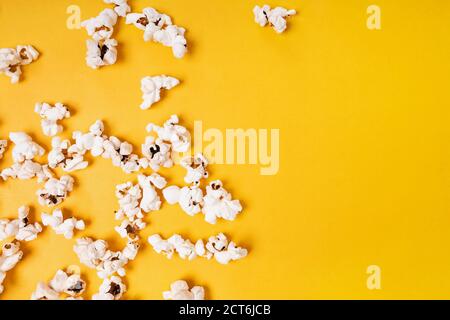 Popcorn scattered on yellow background, Stock Photo