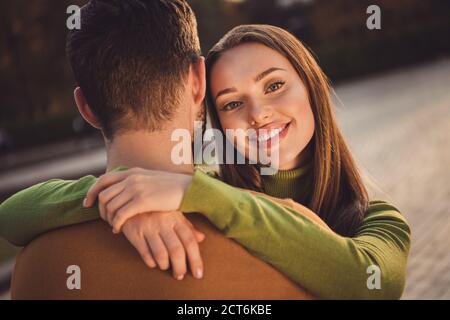 Back rear spine view portrait of charming positive girl hug her soulmate boyfriend in fall september city center outdoors Stock Photo