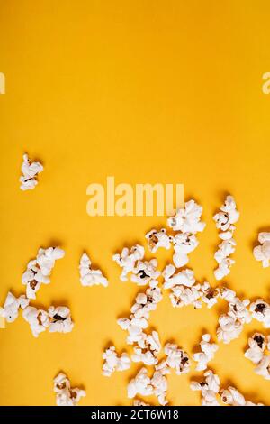 Popcorn scattered on yellow background Stock Photo