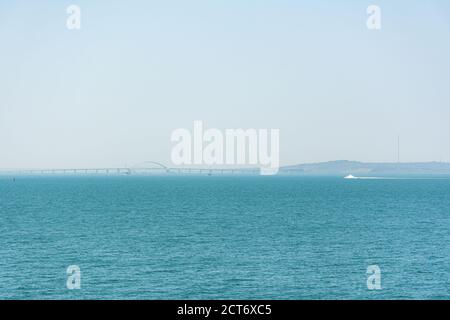 Crimean bridge under construction view from the sea April 27, 2018. Turquoise background with a bridge on the horizon. Bridge from Kerch to Krasnodar Stock Photo