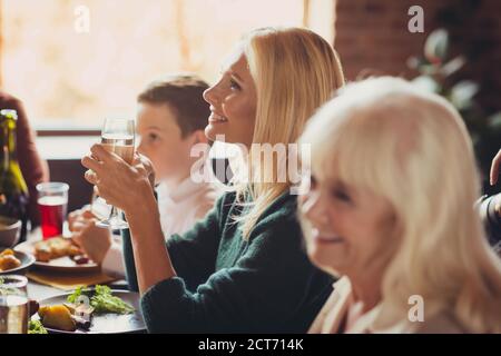 Old beautiful grandmothers communicating relatives listen toasts thanksgiving dinner house living room indoors Stock Photo