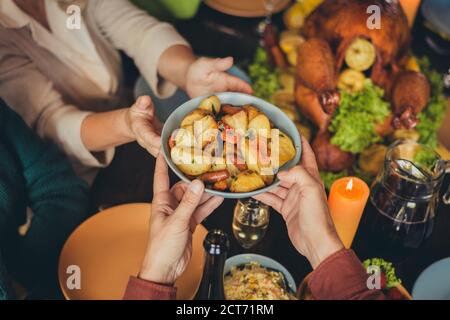 Cropped photo table arms share treat fried potato thanks giving dinner garnished turkey evening house living room indoors Stock Photo