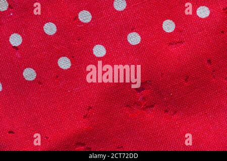 Moth holes in red with white polka dots fabric Stock Photo