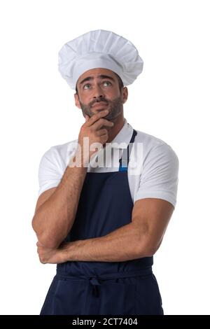 Portrait of male cook in apron and hat thinking holding hand on chin and looking up isolated on white background Stock Photo