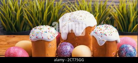 Easter cakes and Easter colored eggs on a wooden background. Religious holiday of bright Easter. Stock Photo