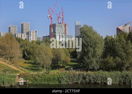 London Olympic Park, landscape maturing (summer 2020), shows Olmpic Village site beyond with new apartments under construction. Stock Photo