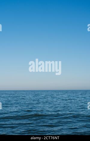 Calm sea with blue sky background. Aldeburgh, Suffolk. UK. Upright Stock Photo