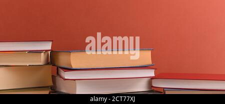 Stacks of books several on a brown background close-up. Hardcover books in different colors. At the top there is a free space for the inscription, tex Stock Photo