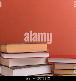 Stacks of books several on a brown background close-up. Hardcover books in different colors. At the top there is a free space for the inscription, tex Stock Photo