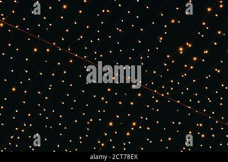 Many lightbulbs hanging on cable as garland decorative in festival isolated on dark night sky background, beautiful design of light string Stock Photo