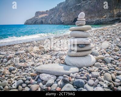 Symbolic scales of stones against the background of the sea and blue sky. Concept of harmony and balance. Pros and cons concept. Copy space for text. Stock Photo