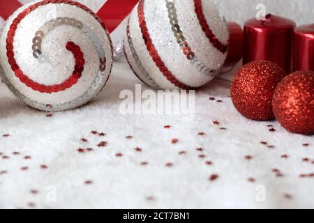 Festive banner with Christmas ornament. Red and white balls and red candles with red confetti on a white background. Copyspace. Christmas flatly Stock Photo