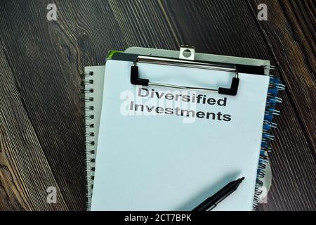 Diversified Investments write on a paperwork isolated on wooden table. Stock Photo