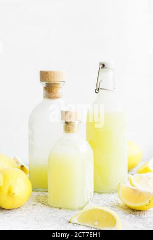 Bottles with traditional homemade lemon liqueur limoncello and fresh citrus on the table. Italian traditional liqueur limoncello with lemon. Italian a Stock Photo