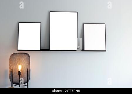 Modern interior and three empty picture frames on the wall, blank poster, canvas space for text in the living room Stock Photo