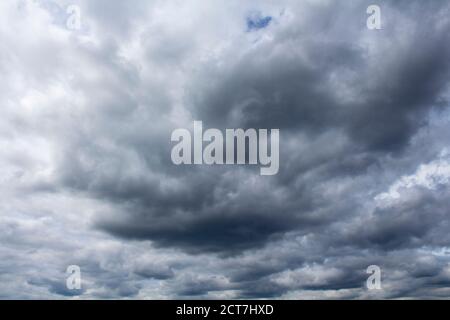 Low, dark glowering storm clouds threatening rain (Nimbostratus) Stock Photo