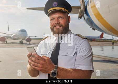 Happy man sending messages before starting the flight Stock Photo