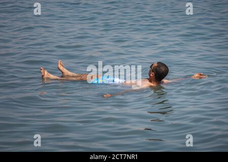 Tourist swim in Dead Sea. Body care treatment in Israel. Dead Sea, Israel - April 19 2018 Stock Photo