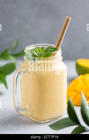 Fresh mango lassi in a glass jar. Healthy vegetarian mango smoothie Stock Photo