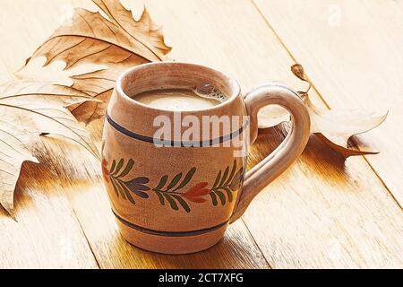 Cup of coffee and autumn leaves on a wooden table Stock Photo