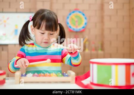 young girl play xylophone at home for homeschooling Stock Photo