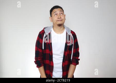 Portrait of young funny attractive Asian man showing lazy disgust unhappy bored mocking expression, over white Stock Photo