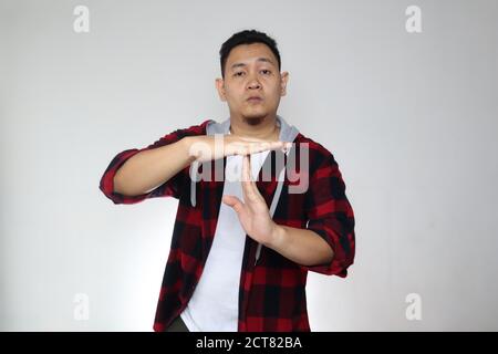 Young Asian man making time out gesture, take a break concept Stock Photo