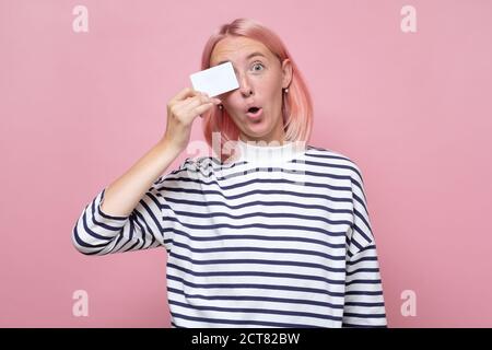 Smiling woman in striped clothes holding her empty visiting card Stock Photo