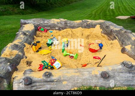 Sandpit, on a children's playground, sandpit with various toys made of plastic, excavator, shovels, molds Sauerland, NRW, Germany Stock Photo